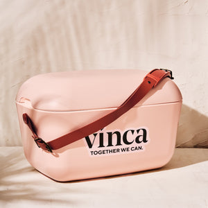 Pink bag with brown strap and 'vinca' branding on a beige background